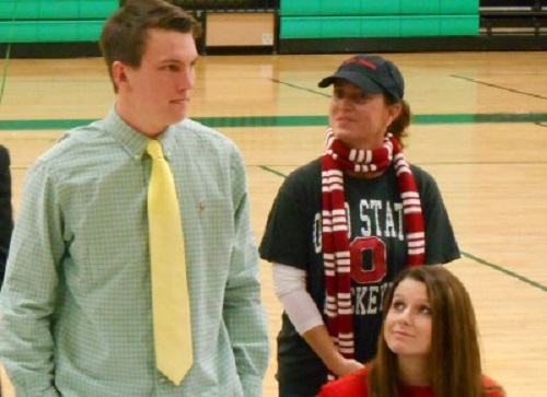 SENIOR FOOTBALL PLAYER Tommy McKee stood to be acknowledged during the school’s National Signing Day, while Field Hockey Coach Julie Swain and senior field hockey player Maddy Humphrey, also acknowledged, looked on. 