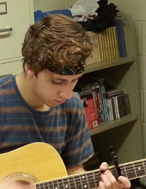 SENIOR ALEX MOCK plays his guitar for classmates.