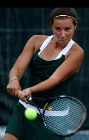 Senior Kait Brogan returns a serve on the tennis court.