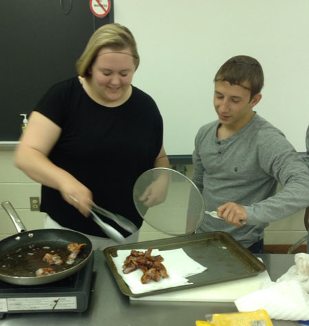 SENIORS ALEX DICKEY and Alex Onufriyenko prepare chicken wings for an upcoming event.