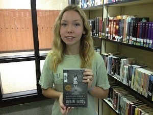 JUNIOR MEGAN WILLIAMS holds up the book Miss Peregrines home for Peculiar 
Children by Ransom Riggs.
