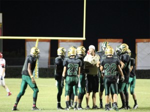 COACH NOE GIVES a pep talk to the team for the upcoming plays.