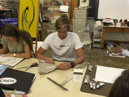 SENIOR JACK SULLIVAN makes a paper airplane for an Art class project.