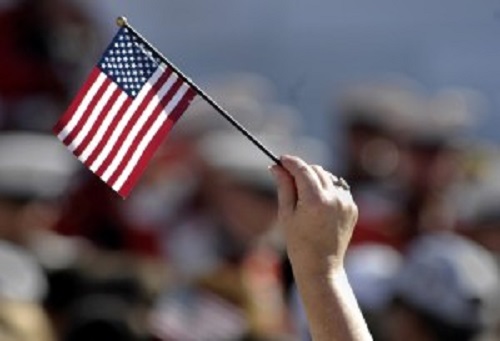 PATRIOTIC AMERICANS WAVE an American flag in honor of Veterans Day.