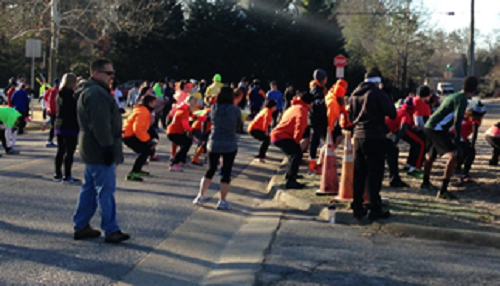 FALCON 5K PARTICIPANTS prepare for the run with group stretching.