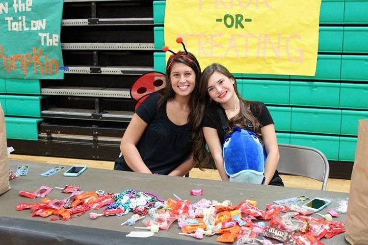 SENIORS BROOK MOORE and Abigail Kelly  give out candy to the kids of Boo Bash.