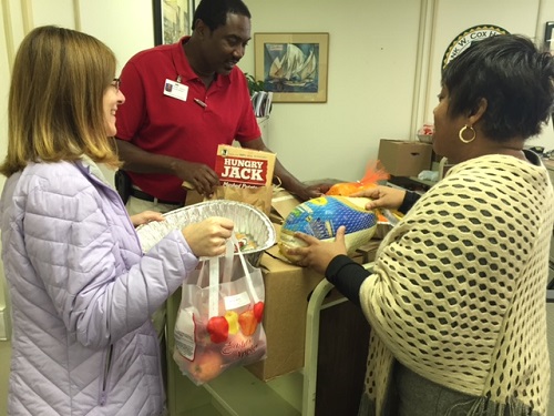 WENDY MATTHIS AND staff prepare donated items for Thanksgiving baskets.