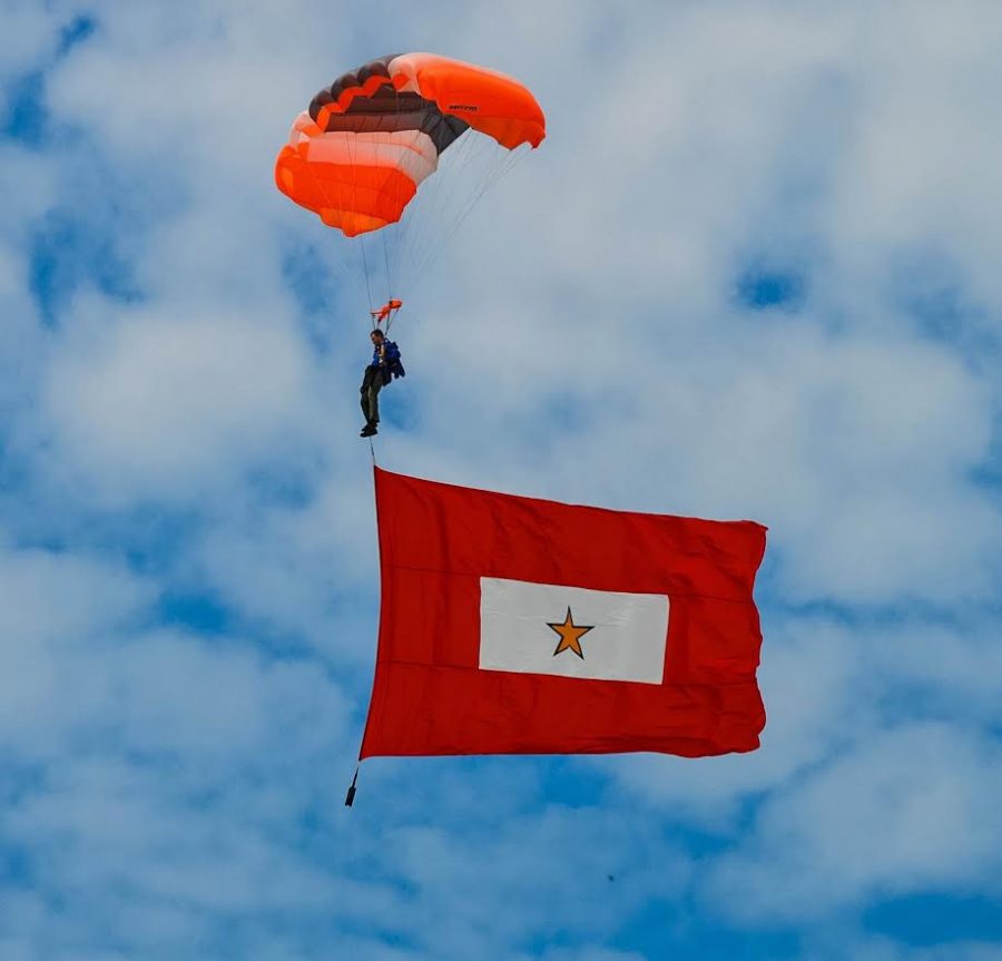 PARATROOPERS RAIN DOWN bearing flags. 