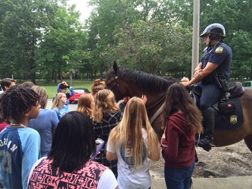 STUDENTS REACH OUT and pet police horses when officers patrolled school grounds on Friday morning.