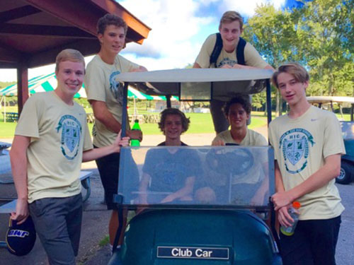 FALCON PLAYERS CLIMB aboard their golf cart.