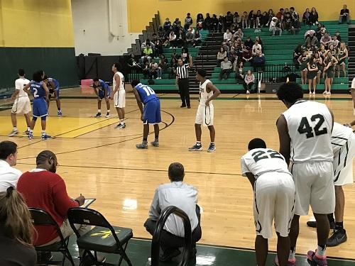 TEAMMATES ANXIOUSLY WATCH as Senior AJ Smith shoots a free throw.