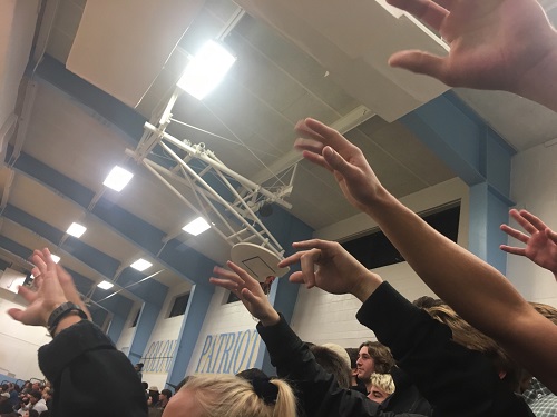 BASKETBALL FANS GIVE good luck to the free throw shooter.