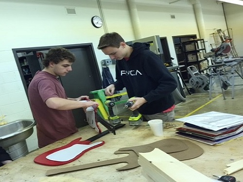 SENIORS ADAM BAILEY and Dillon Saunders create guitar shaped coat hooks in Mr. Bouchs class.