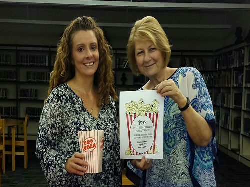 LIBRARIANS (L-R) LAURA DEMBER and Judy Rea welcome teachers to the library today with popcorn treats for National Library Week.