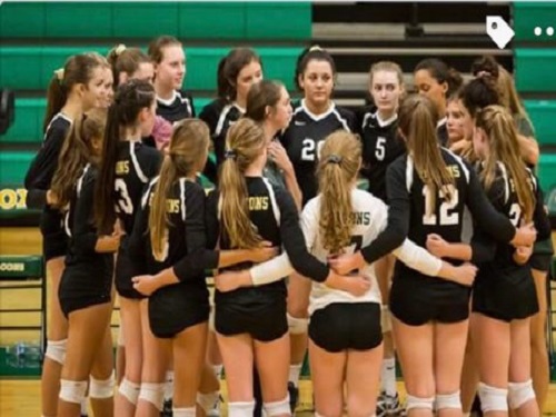 THE GIRLS VARSITY volleyball team huddles up before the game. 