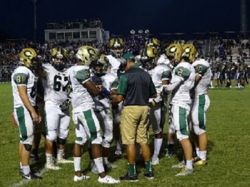 VARSITY FOOTBALL TAKES a timeout during the Salem game. The team huddled in anticipation of the second half. 