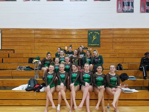 GYMNASTS POSE AT their meet.