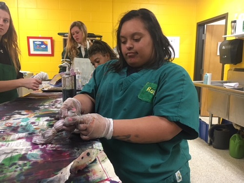 STUDENT ROBIN JACOBS  makes tie dye socks in celebration of World Down Syndrome Day.