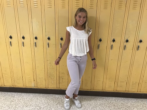 JUNIOR EMMA ANDERSON wearing a flowy white shirt and purple pants