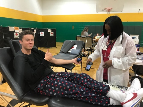 SENIOR CARTER SCHENK gives blood in hopes that it may save another persons life. CHS Key Club, in conjuction with the Red Cross, set up in the gym today for any student who wanted to participate in the Blood Drive.