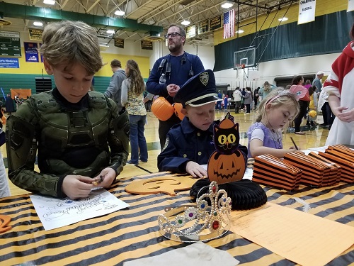 FUTURE FALCONS PARTICIPATE in the coloring book station during last years Boo Bash event. They were later given goodie bags by volunteers. 