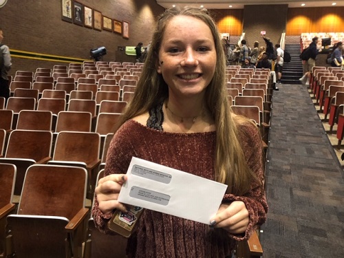 JUNIOR JORDAN ESTES holds her check for scoring well on lone her AP exams last year.  NMSI awarded approximately 50 students these checks yesterday at a ceremony in the auditorium.