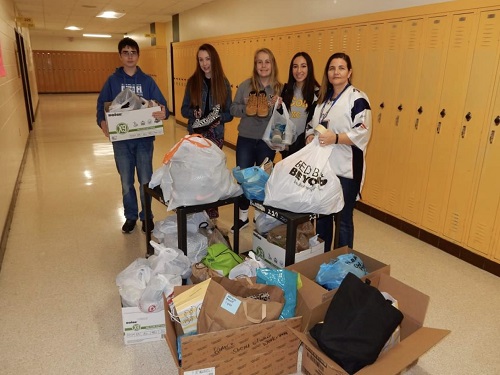 KEY CLUB MEMBERS prepare to load the buses with shoes for the Got Soles project. Over two hundred pairs of shoes were collected overall by students. 