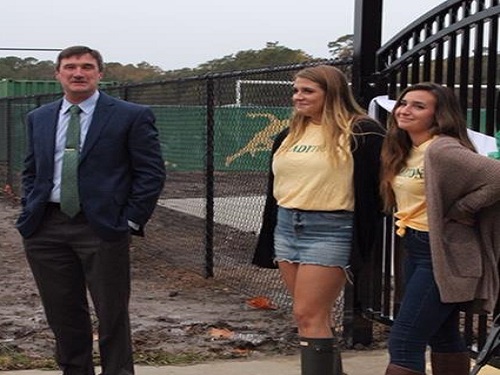 SENIORS ABBEY FARO and Alaina Disilvestro stand at the gates of the new Falcon Wing with Dr. Kelly. Dr. Kelly asked the two students to cut the ribbon to commemorate the opening of the Wing. 