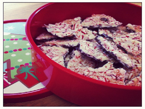 WHITE CHOCOLTE PEPPERMINT bark pieces fill the red holiday dish. This dessert is also made during other holidays including Valentines Day.