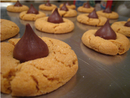 PEANUT BUTTER BLOSSOM cookies sit, fresh out of the oven.  The treat is a traditional holiday desert that is common in the United States.