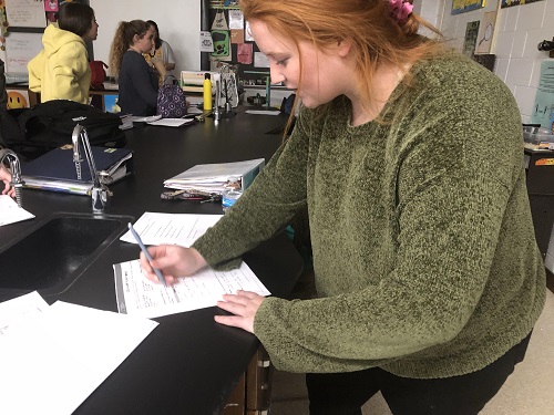 SENIOR SARAH COLE checks over her NMSI packet. Sarah then turned in her packet to her Science teacher, along with other students. 