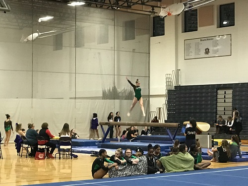 SENIOR CHLOE HULLS competes on the balance beam. The team recently competed against  Green Run, First Colonial, and Tallwood High Schools. 