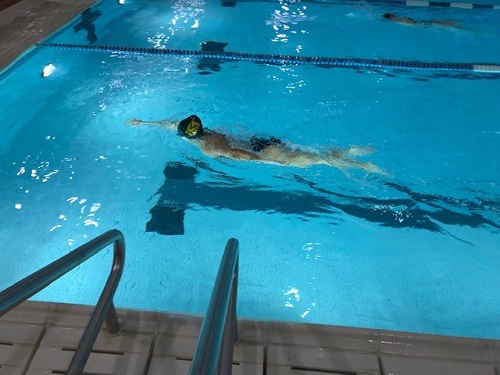 COX SWIMMER MAKES her way to the edge of the pool. The swim team swam against the First Colonial Patriots. 