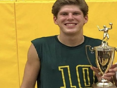 SENIOR BRAD PETERS poses with a trophy at volleyball senior night. The Falcons have been very successful throughout their season. 