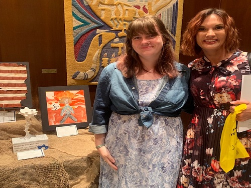 (L-R) SENIOR SOPHIE BEMENT and Art teacher Mrs. Van Veenhuyzen display Bements winning sculpture at Temple Israel Wednesday night. The night was held as part of Holocaust Remembrance week.