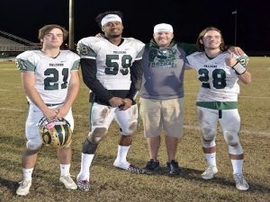 ALUMNUS, MENTOR AND former athlete, football coach Tyler Noe (middle right) enjoys the win with former players after beating rival First Colonial High School. Noe has been a pivotal member of the coaching staff as well as a mentor to the athletes.