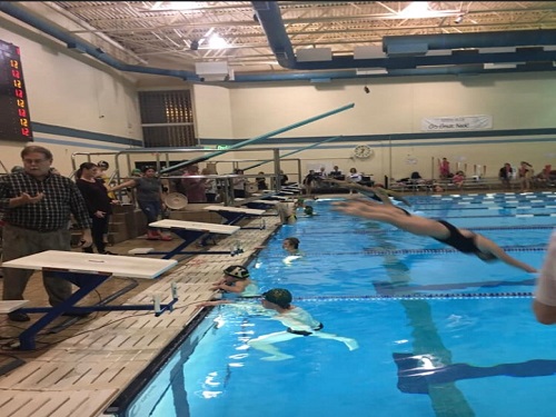 BOYS SWIM FINISHES the 50 meter freestyle and cheer the girls on from the water as they begin their next event.  Both the girls and boys teams defeated the Kellam Knights and the Kempsville Chiefs 
as they look to continue their winning streak.  