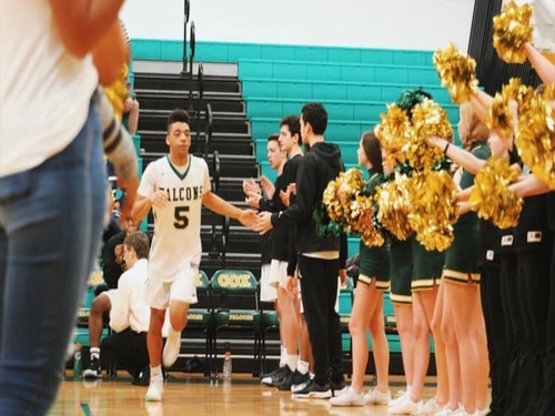 SENIOR JORDAN LEWIS runs through spirit tunnel. He is a starting player for the Falcons.