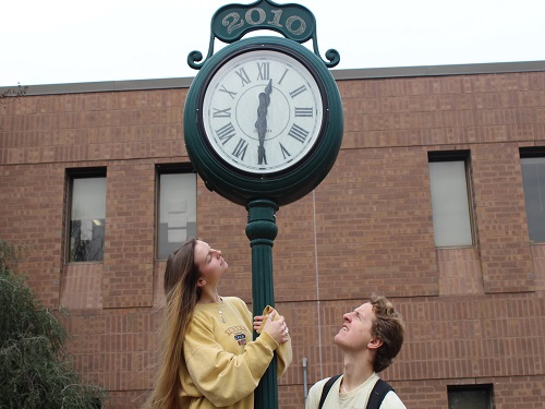 SENIORS ADAM TUCKER (left) and Rhyan Moran squint at the clock ouside school as they were voted most likely to be late to graduation. Now, no one is sure when the senior graduation might be, much less what time it will be held. 
