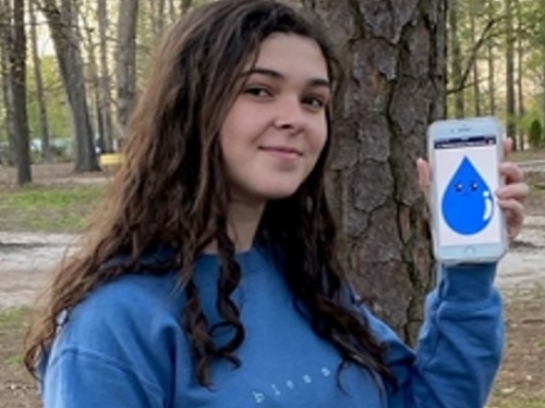 ENVIRONMENTAL CLUB MEMBER senior Cindy Eddington pledges to sustain the environment by accepting the practices of Wally the Water Drop. Eddington holds a photo of her drop as a means of raising awareness for environmental conservation. 
