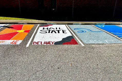 SENIOR DELANEY ESTES parking spot displays her future college colors.  Other students chose to  paint designs of sunsets and other activities they enjoy. 
