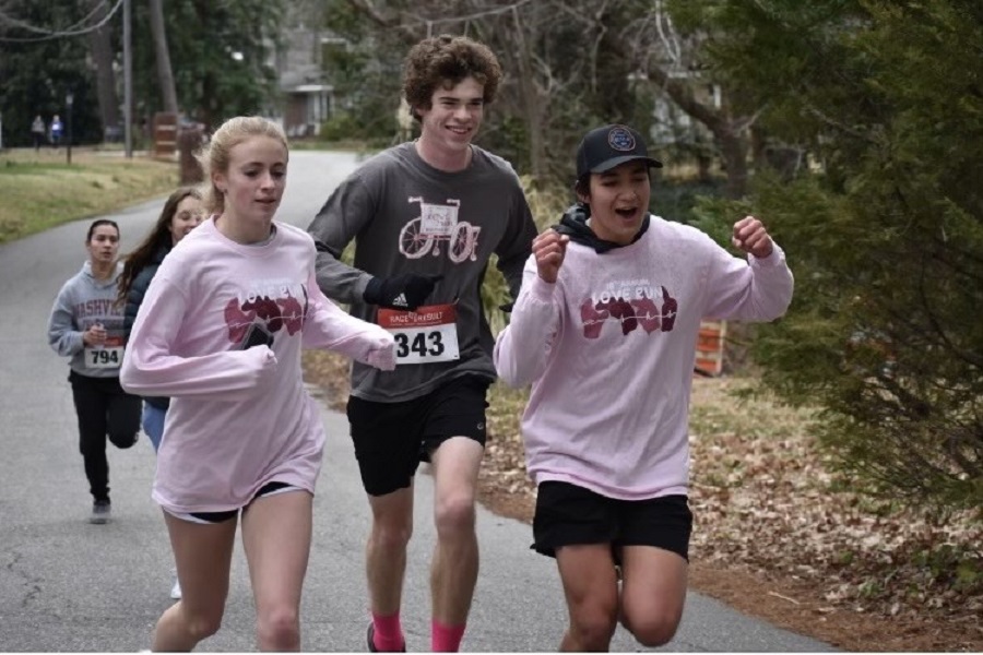 SOPHOMORE CALI MITCHUM (left), and juniors Daniel Elfelt (middle) and  Victor Pham put their best foot forward at Thalia Elementary to celebrate the 18th annual Love Run. Students wore their CHKD Love Run "merch," as well as pink and red colors to show off their love for the CHKD hospital. 