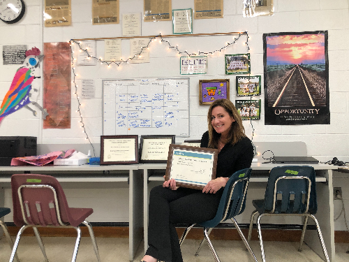 JOURNALISM ADVISER ERIN Tonelson smiles with gold medal distinctions for the Falcon Press. The Falcon Press also earned a silver medal distinction from Columbia last year during COVID.