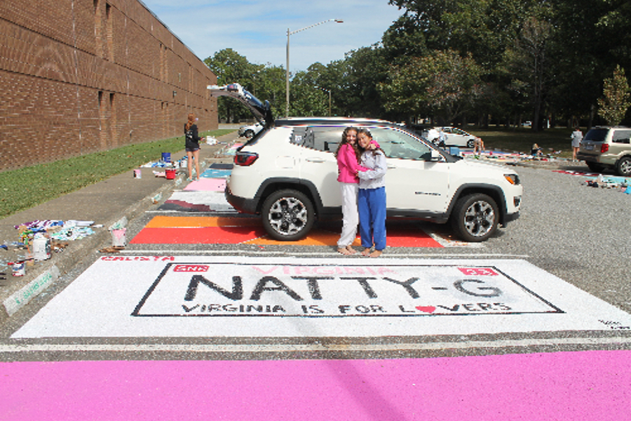 SENIORS NATALIE GEN and Calista Williams admire a painted parking spot. The spot is decorated as a Virginia license plate.