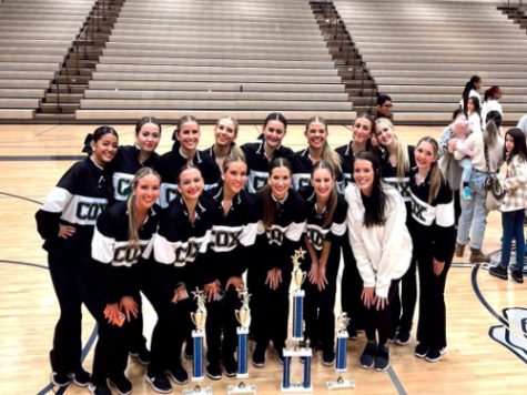 COQUETTES DANCE TEAM celebrates with their coach after receiving the Manchester Dance competition Grand Championship Award. According to the captains, they were proud to have led their team to another victory.