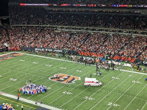 BUFFALO BILLS PLAYERS huddle together in order to pray for Hamlin who had recently gone into cardiac arrest on the football field. The ambulance carrying Hamlin hustled to closest medical center, ultimately restarting his heart twice before stabilizing him.