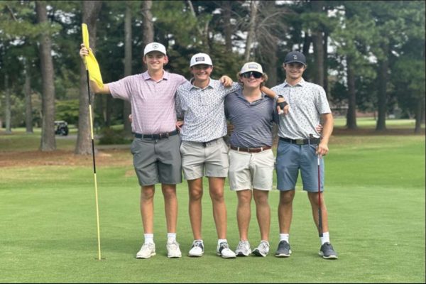FALCON GOLFERS CELEBRATE on the green after a hole-in-one. Junior Easton Hamrick was an integral player who helped his team take home the match win.