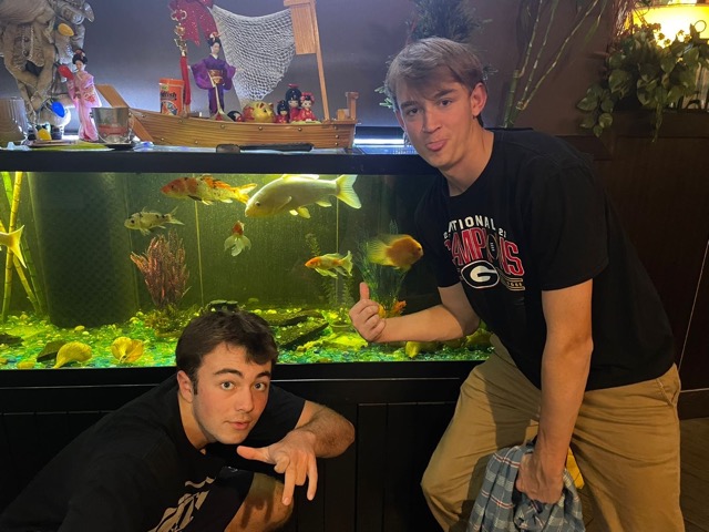 JUNIORS MAX PALMERTON and Blake Heselius display their readiness to fill their stomachs in front of the fish tank at OYummy. They ordered the all-you can-eat sushi for $24.