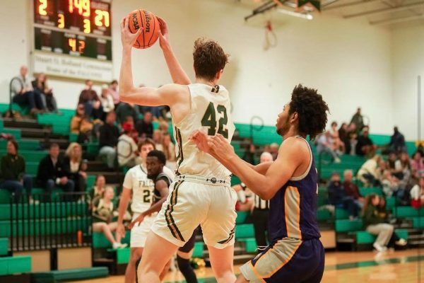 SENIOR BEN NACEY jumps in heads above the opposing team., looking to get the ball in the hoop. Nacey has been a vital player on the schools varsity team throughout his four years. and plans to continue his run in the fall.
