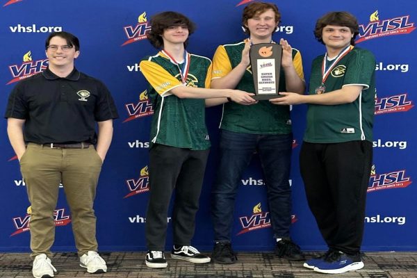 E-SPORTS SPONSOR MR. Duggan (left) and the E-sports team celebrated their 2nd place win at the state competition. As the team held the trophy, they were overwhelmed by their accomplishment  as the team has only been in existence for three years.